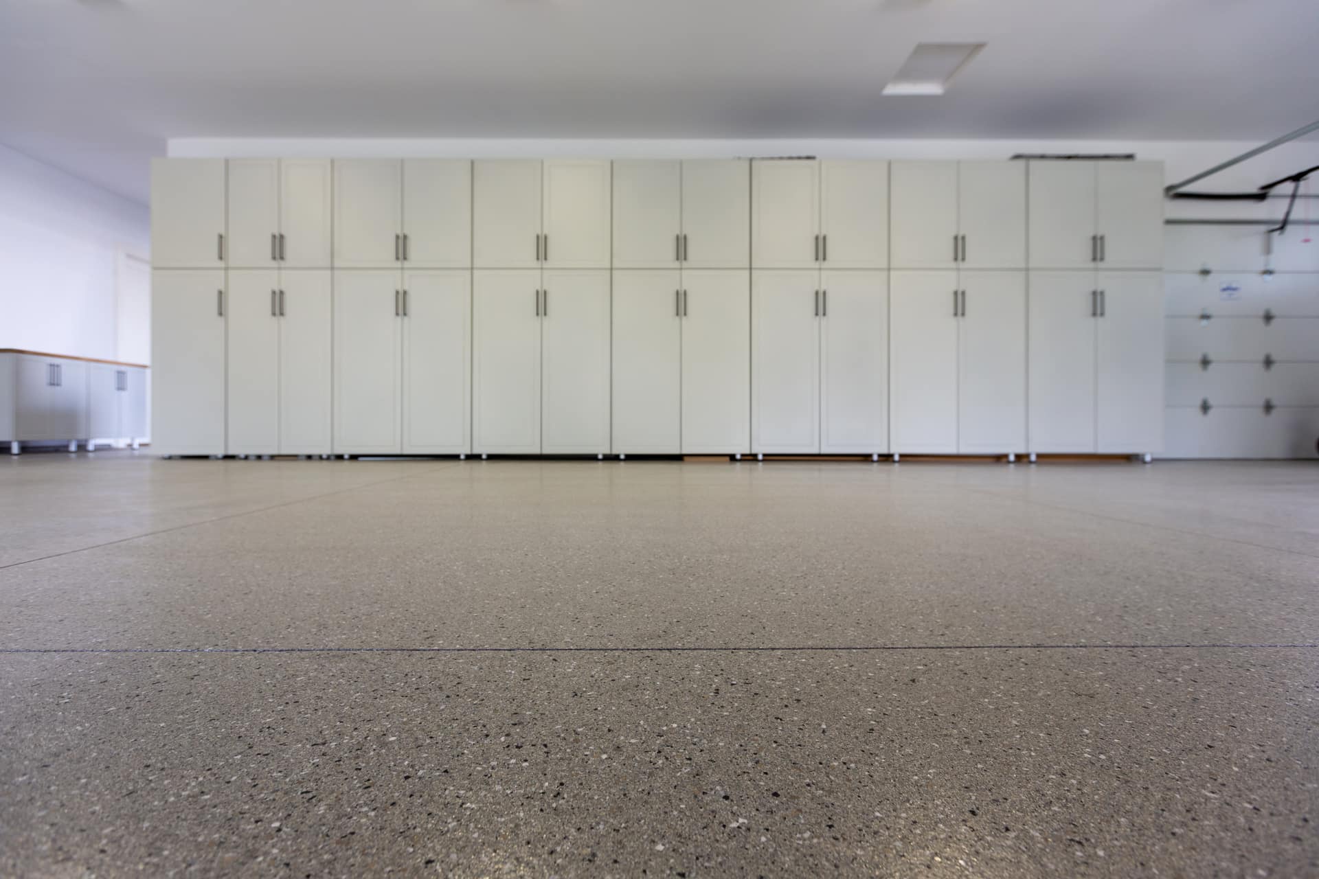 Garage organization solutions featuring overhead storage and custom cabinet installation